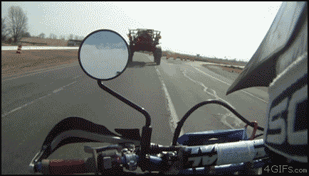 
Motorcycle-passes-underneath-tractor
