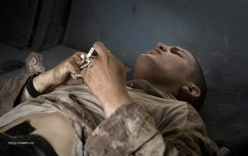  Foto tyzdna  Afganistan  Raneny americky vojak zviera v ruke ruzenec pocas osetrenia na palube helikoptery 